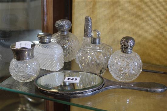 6 silver topped glass bottles, a mirror and a silver handled button hook